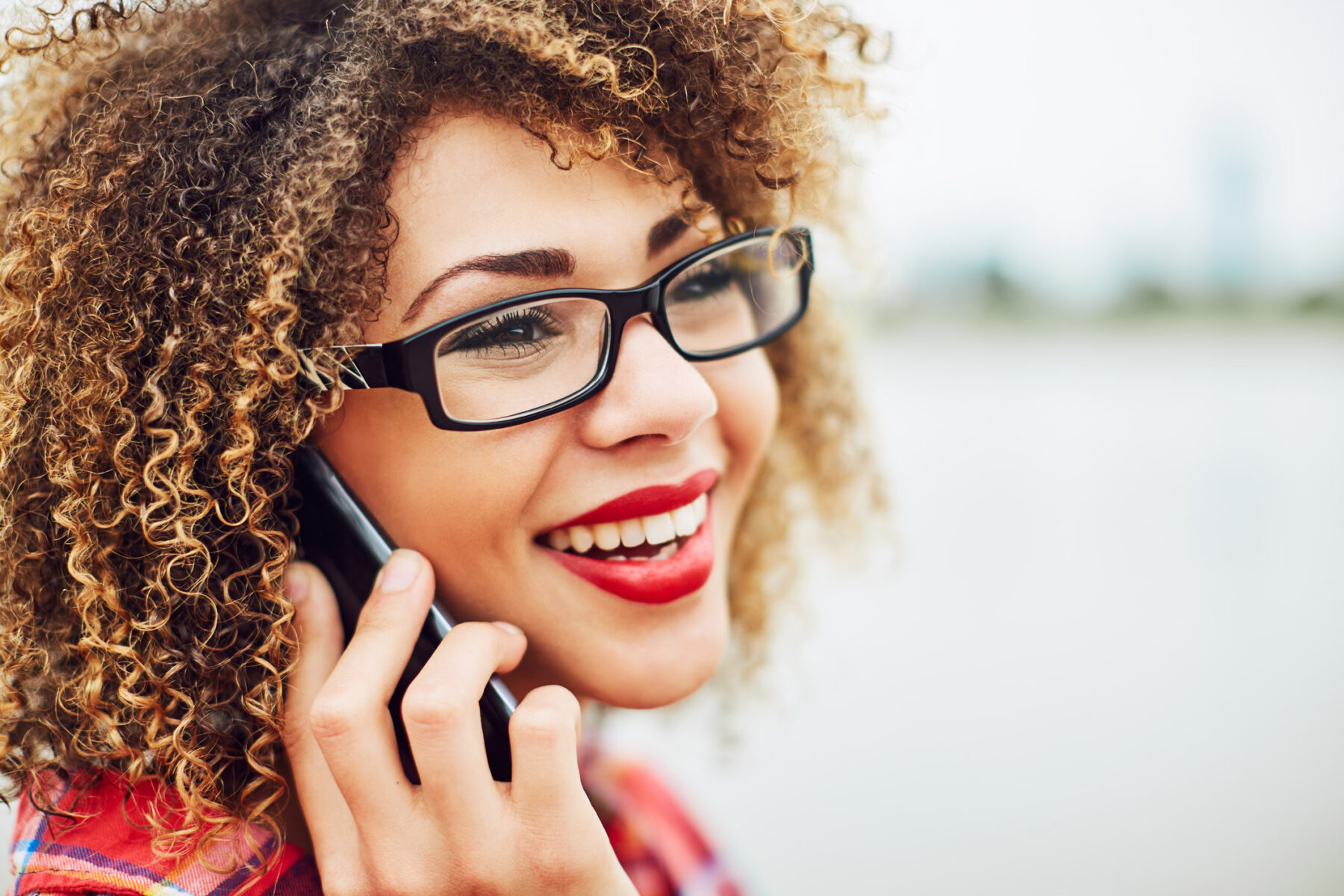 Happy lady on the phone wearing glasses outdoors in Denver, Colorado