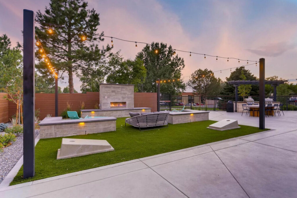 Outdoor area with fireplace, seating, and corn hole game