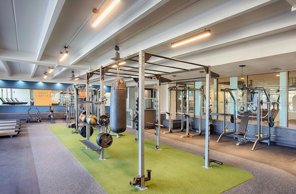 A large fitness center with a punching bag, weights, and strength equipment