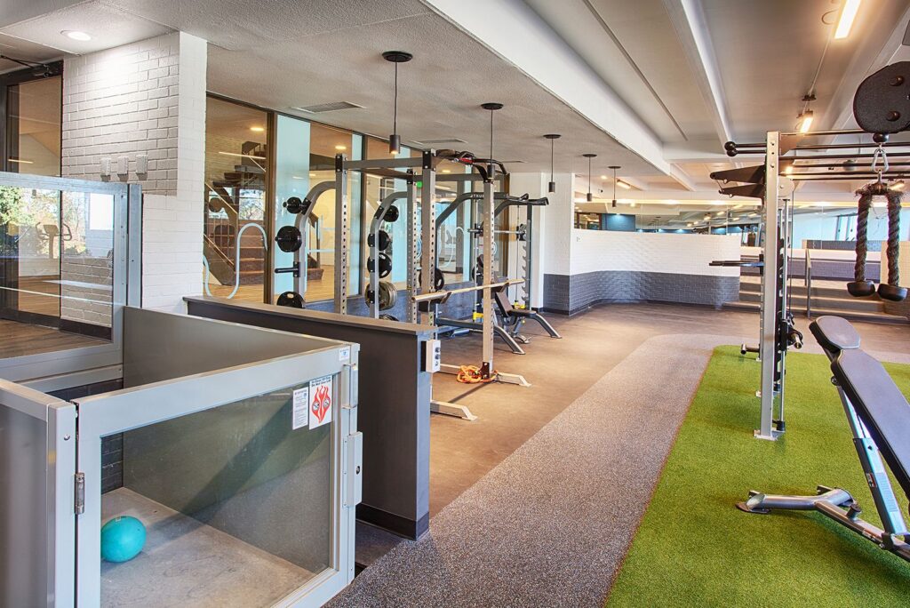 Fitness center closeup with strength machines, sunken level with short stairs and a wheelchair elevator